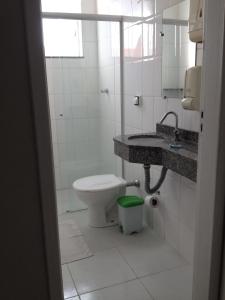 a bathroom with a toilet and a sink at BLUES HOTEL in Guaratinguetá