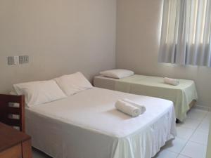 2 Betten in einem Zimmer mit Handtüchern darauf in der Unterkunft BLUES HOTEL in Guaratinguetá