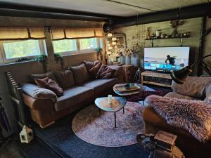 a living room with a couch and a flat screen tv at Loft by the lake asunto omakotitalon alakerrassa in Ylöjärvi