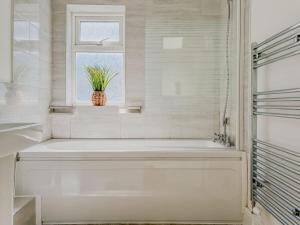 a white bathroom with a tub and a window at 58 Thorpe road - City Centre in Norwich