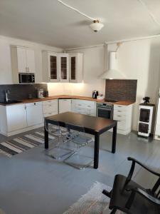 una cucina con mobili bianchi e un tavolo di legno di Willa Vitsari n60m2 a Kokkola Altre 4 foto