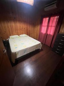 una camera da letto con un letto e due finestre di Cabaña del centro a Puerto Iguazú Altre 3 foto