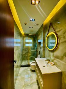 a bathroom with a sink and a toilet and a mirror at Luxury 3 bedroom apartment in Banī Ghālib +10 photos