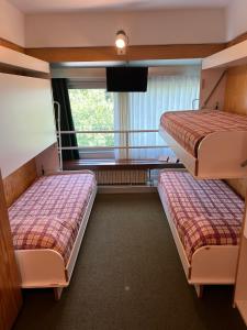 two beds in a room with a window at Residenza Albaré in Marilleva