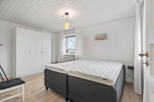 ein Schlafzimmer mit einem Bett in einem weißen Raum in der Unterkunft 8817 Hvide Sande - Mågevej 2 in Hvide Sande