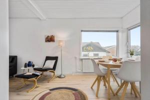 ein weißes Wohnzimmer mit Tisch und Stühlen in der Unterkunft 8817 Hvide Sande - Mågevej 2 in Hvide Sande