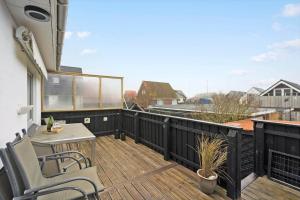 eine Terrasse mit Tisch und Stühlen auf einem Balkon in der Unterkunft 8817 Hvide Sande - Mågevej 2 in Hvide Sande