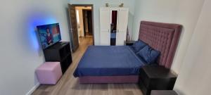 a bedroom with a bed and a flat screen tv at Monaco Summerland Rentals in Mamaia
