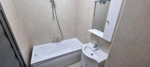 a white bathroom with a sink and a mirror at Monaco Summerland Rentals in Mamaia