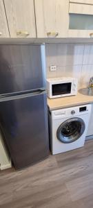 a kitchen with a refrigerator and a microwave at Monaco Summerland Rentals in Mamaia +144 photos