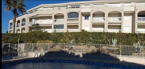 a large white building with a pool in front of it at Soleil d'or à St Aygulf in Fréjus