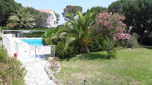 a garden with a swimming pool and some flowers at Soleil d'or à St Aygulf in Fréjus