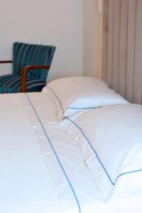 a bed with white sheets and a chair in a room at I Bastioni San Domenico - Boutique Hotel in Gallipoli