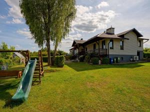 a slide in a yard in front of a house at Holiday Home Trzy Brzozy by Interhome in Grabowo