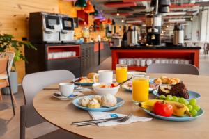 瓜鲁柳斯Ibis Budget Guarulhos Aeroporto的餐桌,带食物和橙汁盘