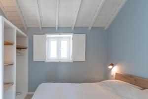 a bedroom with a bed and a window at Barranquinho in Santiago do Cacém