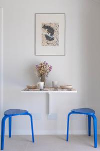 a table with two blue stools in front of a wall at Barranquinho in Santiago do Cacém