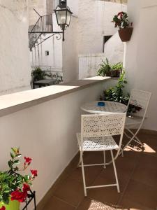 a patio with a table and two chairs and flowers at Dimora il Capitello in Cisternino