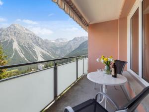 a balcony with a table and chairs and mountains at Apartment Promenade Apt 407 by Interhome in Arosa +21 photos