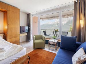 a hotel room with a bed and a balcony at Apartment Promenade Apt 407 by Interhome in Arosa