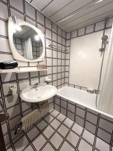 a bathroom with a sink and a tub and a mirror at Residenza Albaré in Marilleva +30 photos