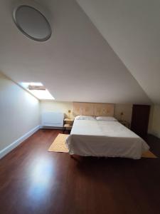 a bedroom with a large white bed in a attic at Casa vacanze da Alice in Alghero