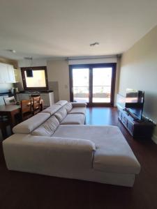 a living room with a white couch and a television at Casa vacanze da Alice in Alghero