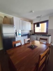 a kitchen with a wooden table and a refrigerator at Casa vacanze da Alice in Alghero