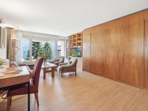 sala de estar con armarios de madera, mesa y sillas en Apartment Promenade - Utoring-73 by Interhome, en Arosa