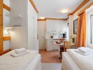 a small room with two beds and a kitchen at Apartment Promenade - Utoring-5 by Interhome in Arosa