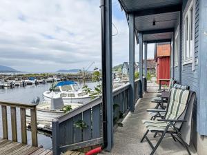 a porch with chairs and boats in a marina at Holiday Home Rorbu by Interhome in Naustdal i Sunnfjord