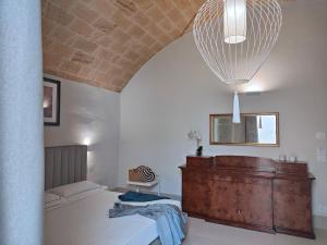 a bedroom with a bed and a large chandelier at I Bastioni San Domenico - Boutique Hotel in Gallipoli