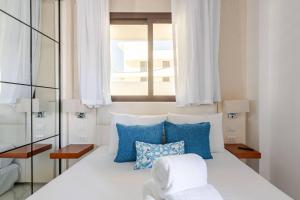 1 cama con almohadas azules y blancas y ventana en Cana Rock Star, en Punta Cana 43 fotos más