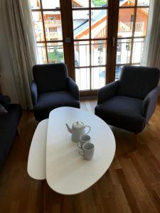 einen weißen Couchtisch im Wohnzimmer mit 2 Stühlen in der Unterkunft Manuela 12 by SMR Rauris Apartments - inc Spa and near Gondola in Rauris