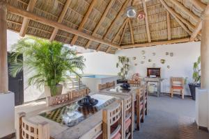 een keuken met houten plafonds en een tafel en stoelen bij La Cruz Encantada 1A in Cruz de Huanacaxtle