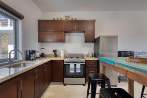 a kitchen with wooden cabinets and a stove top oven at 2 BR Wake up to unique views from your balcony in Cabo San Lucas
