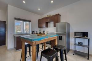 a kitchen with a wooden island in a kitchen with a refrigerator at 2 BR Wake up to unique views from your balcony in Cabo San Lucas
