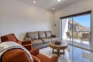 a living room with a couch and a table at 2 BR Wake up to unique views from your balcony in Cabo San Lucas