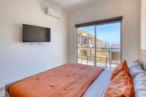 a bedroom with a bed and a large window at 2 BR Wake up to unique views from your balcony in Cabo San Lucas +43 photos