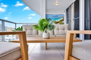 una sala de estar con un sofá y una mesa en Skyview Luxe at Marquis, en Cairns