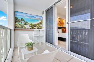 Habitación con balcón y vistas a un dormitorio. en Skyview Luxe at Marquis, en Cairns