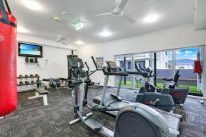 a gym with treadmills and ellipticals in a room at Skyview Luxe at Marquis in Cairns