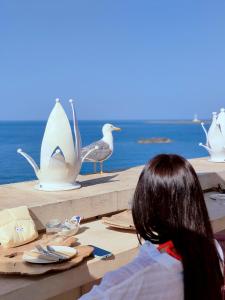 a woman sitting at a table with a bird sculptures at I Bastioni San Domenico - Boutique Hotel in Gallipoli