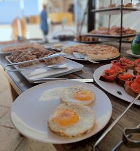 a table with plates of eggs and other food at I Bastioni San Domenico - Boutique Hotel in Gallipoli