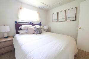 una camera da letto con un grande letto bianco con due cuscini di Wilderness West Resort Cabin 3 a Colville