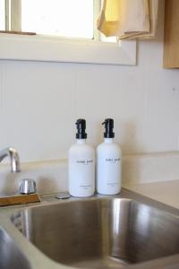 due bottiglie di sapone poggiate sopra un lavandino di Wilderness West Resort Cabin 3 a Colville