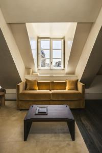 パリにあるMondovi Luxury Suitesのソファとテーブルのあるリビングルーム