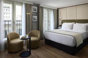 a hotel room with a bed and two chairs at NH Collection Paris Ponthieu Champs-Élysées in Paris