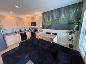 a living room with a couch and a kitchen at Charcoal Loft in Des Moines