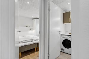a bedroom with a bed and a washing machine at 9953-Hvide-Sande-Langsand-212 in Hvide Sande +37 photos